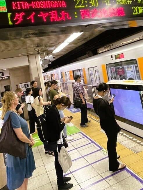 Fahrgäste warten in Tokio am Bahnsteig