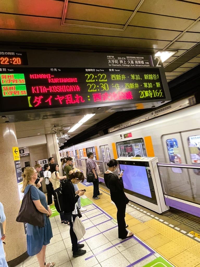 Fahrgäste warten in Tokio am Bahnsteig